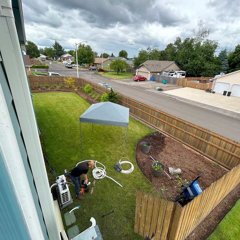 SureTech Heating & Cooling outside installing a heat pump.