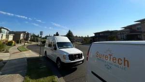 SureTech Heating & Cooling LLC service vans parked in a Vancouver, WA residential neighborhood