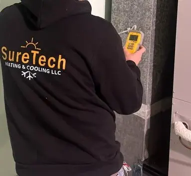 SureTech Heating & Cooling checking duct pressures during a furnace maintenance